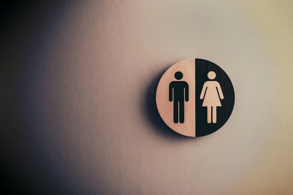 A round sign on the wall with the standard silhouette of a man and a woman.